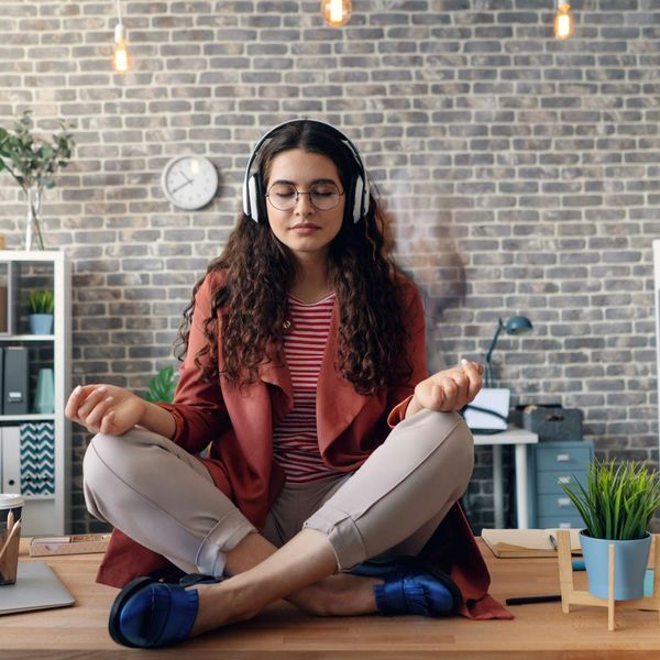 Person doing a simple yoga stretch at an office desk.